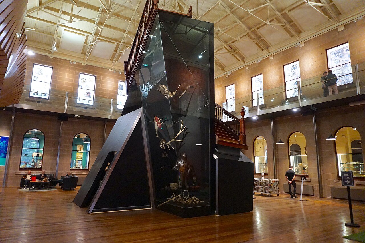 A tall glass wildlife display in the stone-walled interior of the Tasmanian Museum and Art Gallery.